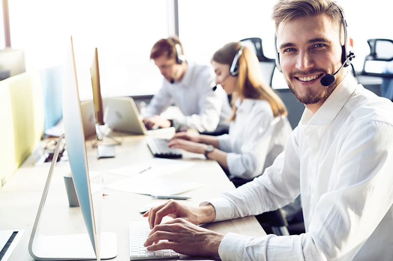 Malteser Customer Care Services Mann mit Headset schaut freundlich in die Kamera